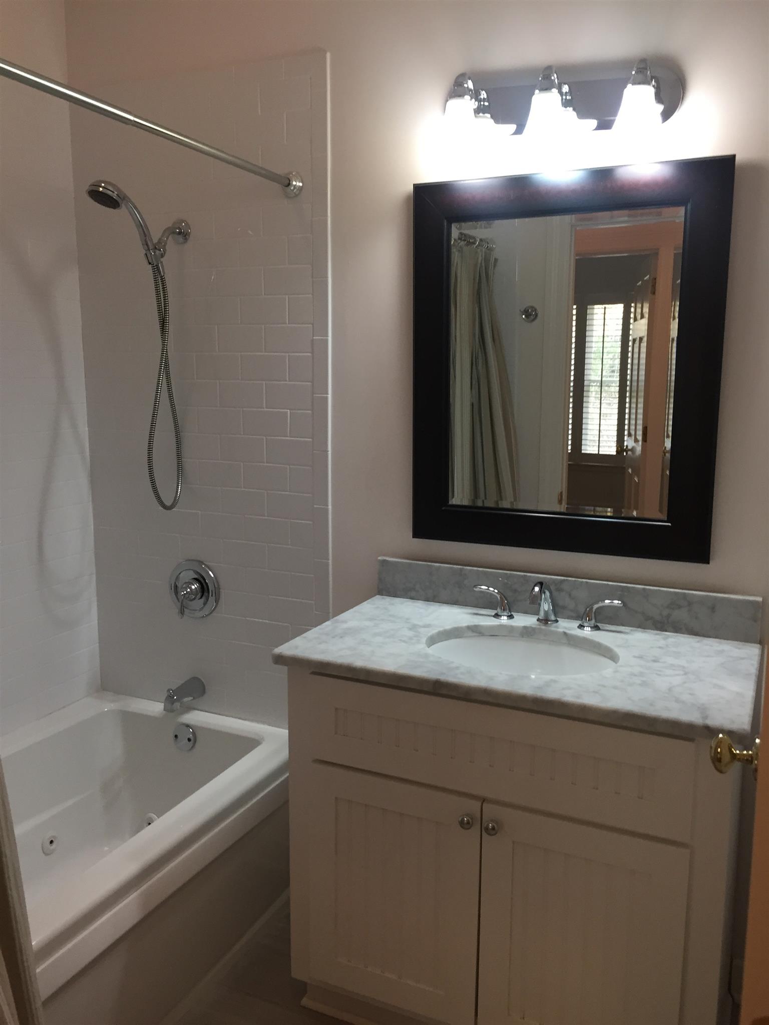 9370 Hester Beasley Road Nashville, TN 37221 - Photo 14 of 22 The Bathroom Features a Combination Shower/Tub, Marble Counters, Tile Floor and a Framed Mirror.