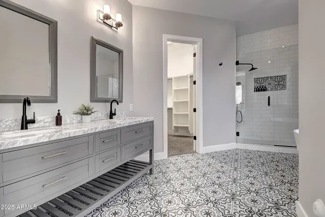 a bathroom with a double vanity sink toilet mirror and shower