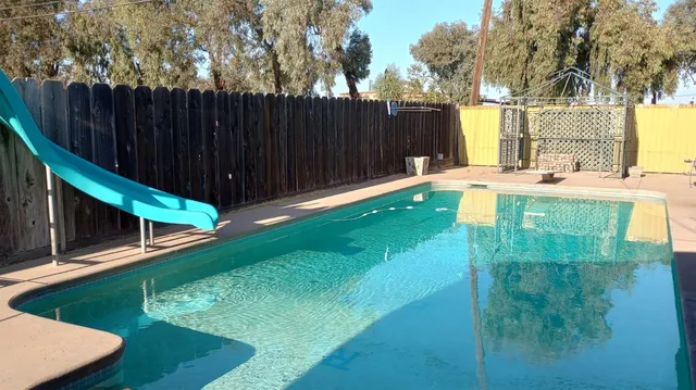 a swimming pool with some trees in the background