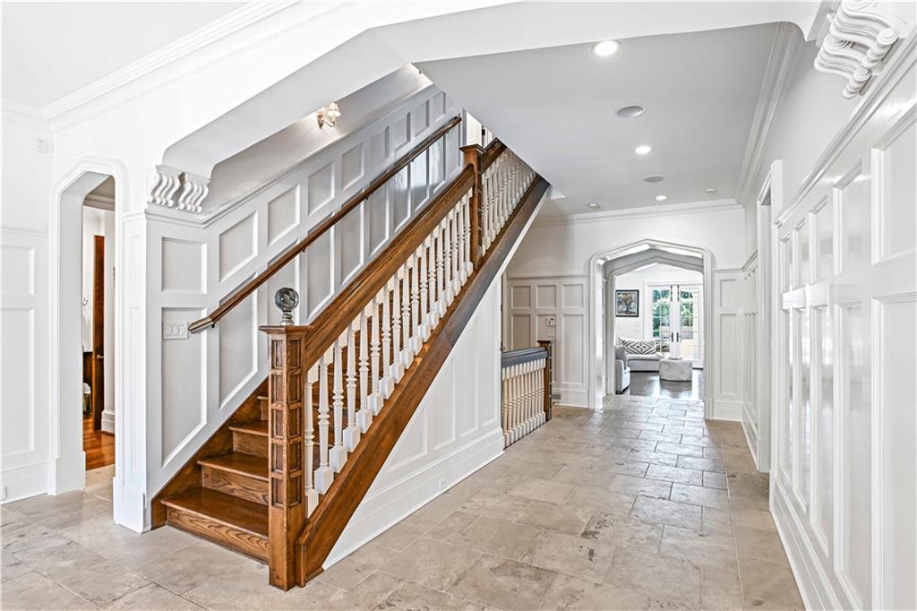 369 Pine Tree Drive Northeast Atlanta, GA 30305 - Photo 13 of 103 a view of staircase with lots of frames on wall and a view of entryway