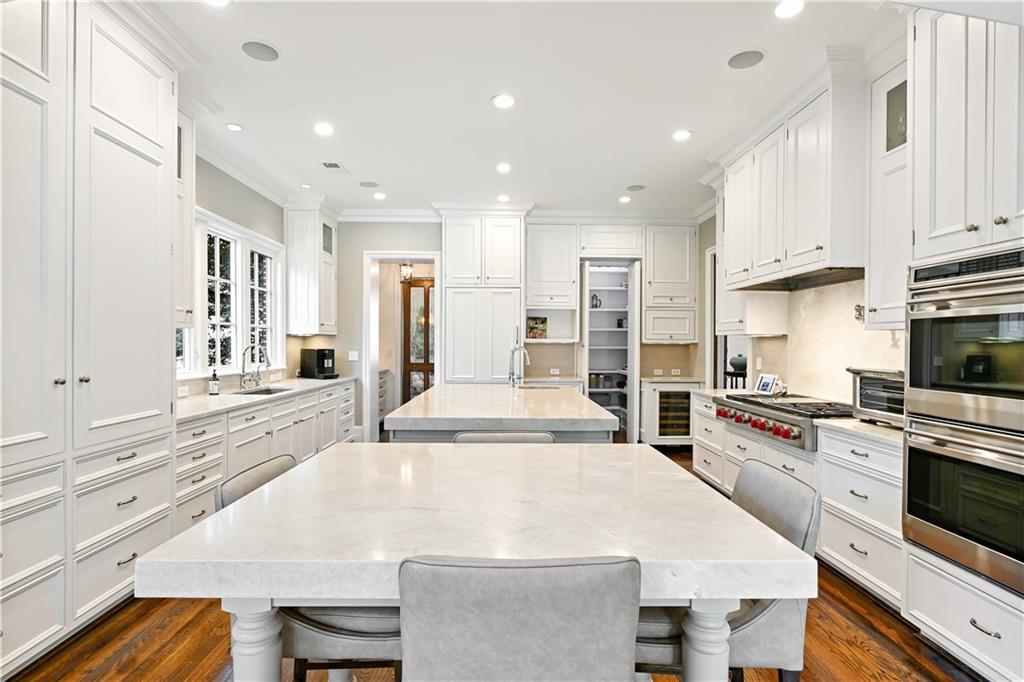 369 Pine Tree Drive Northeast Atlanta, GA 30305 - Photo 19 of 103 a large kitchen with kitchen island a stove a sink a refrigerator and white cabinets