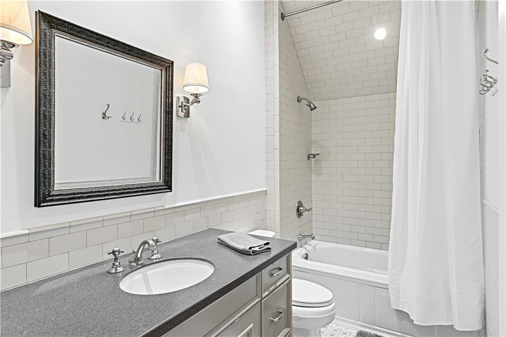 369 Pine Tree Drive Northeast Atlanta, GA 30305 - Photo 65 of 103 a bathroom with a granite countertop sink toilet a mirror a vanity and shower