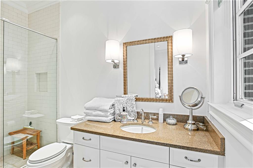 369 Pine Tree Drive Northeast Atlanta, GA 30305 - Photo 79 of 103 a bathroom with a granite countertop toilet sink and mirror