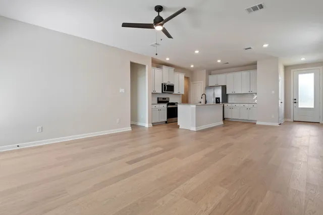 a kitchen with stainless steel appliances a refrigerator a stove top oven a sink and cabinets