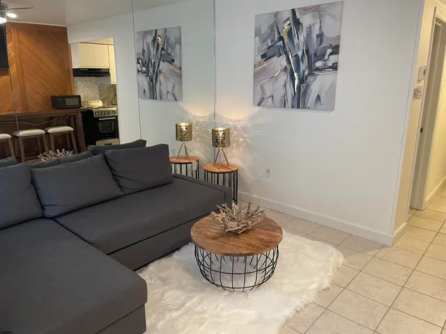 a living room with furniture and a potted plant