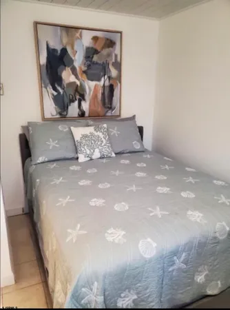 a bed sitting in a bedroom and painting on the wall