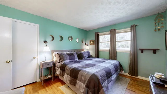 a bed sitting in a bedroom next to a window