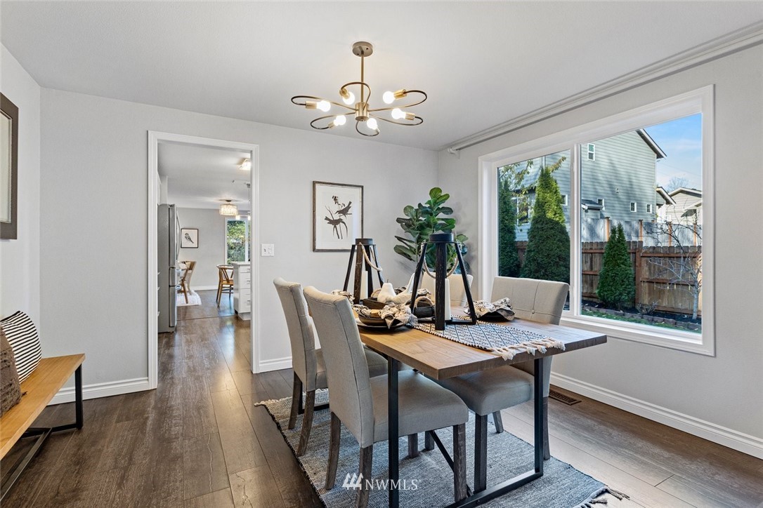 915 215th Street Southeast Bothell, WA 98021 - Photo 11 of 33 a dining room with wooden floor a chandelier a wooden table and chairs