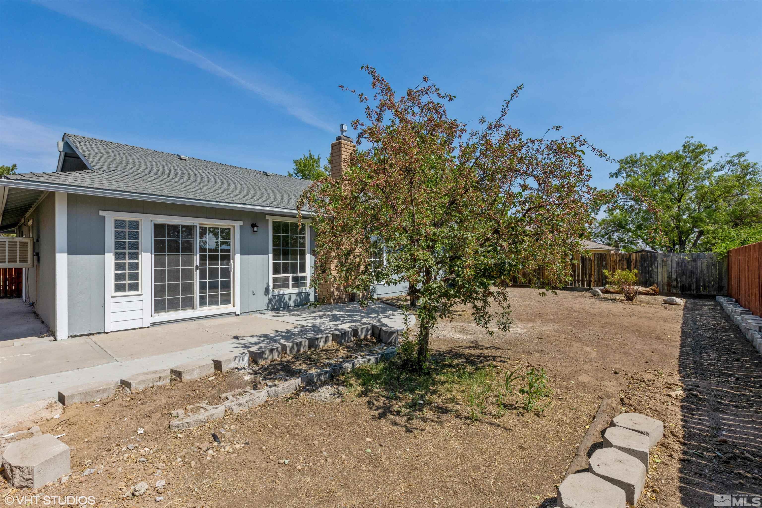 1930 Stardust Street Reno, NV 89503 - Photo 15 of 15 a front view of a house with a yard covered with snow and trees