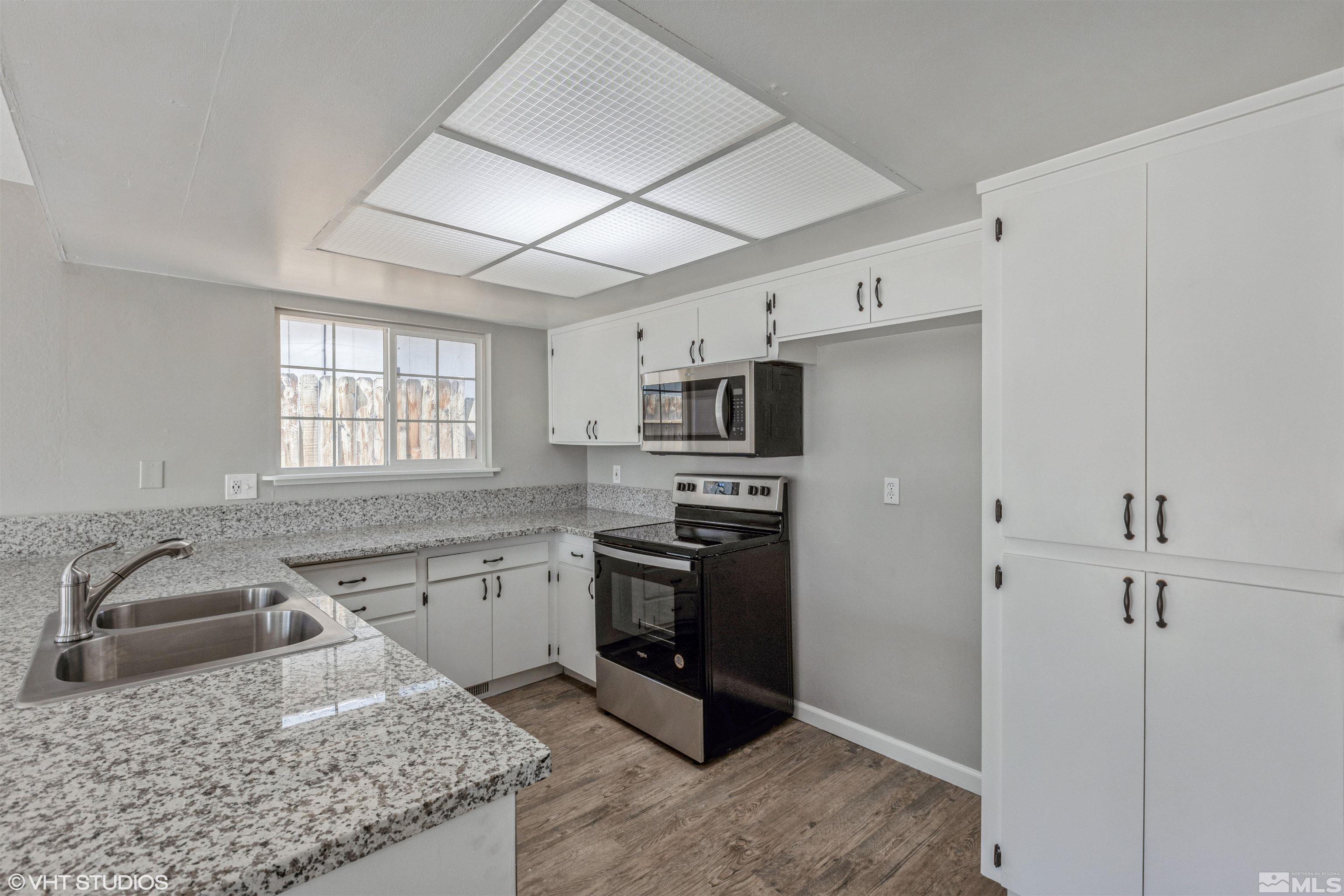 1930 Stardust Street Reno, NV 89503 - Photo 5 of 15 a kitchen with stainless steel appliances granite countertop a sink stove and refrigerator