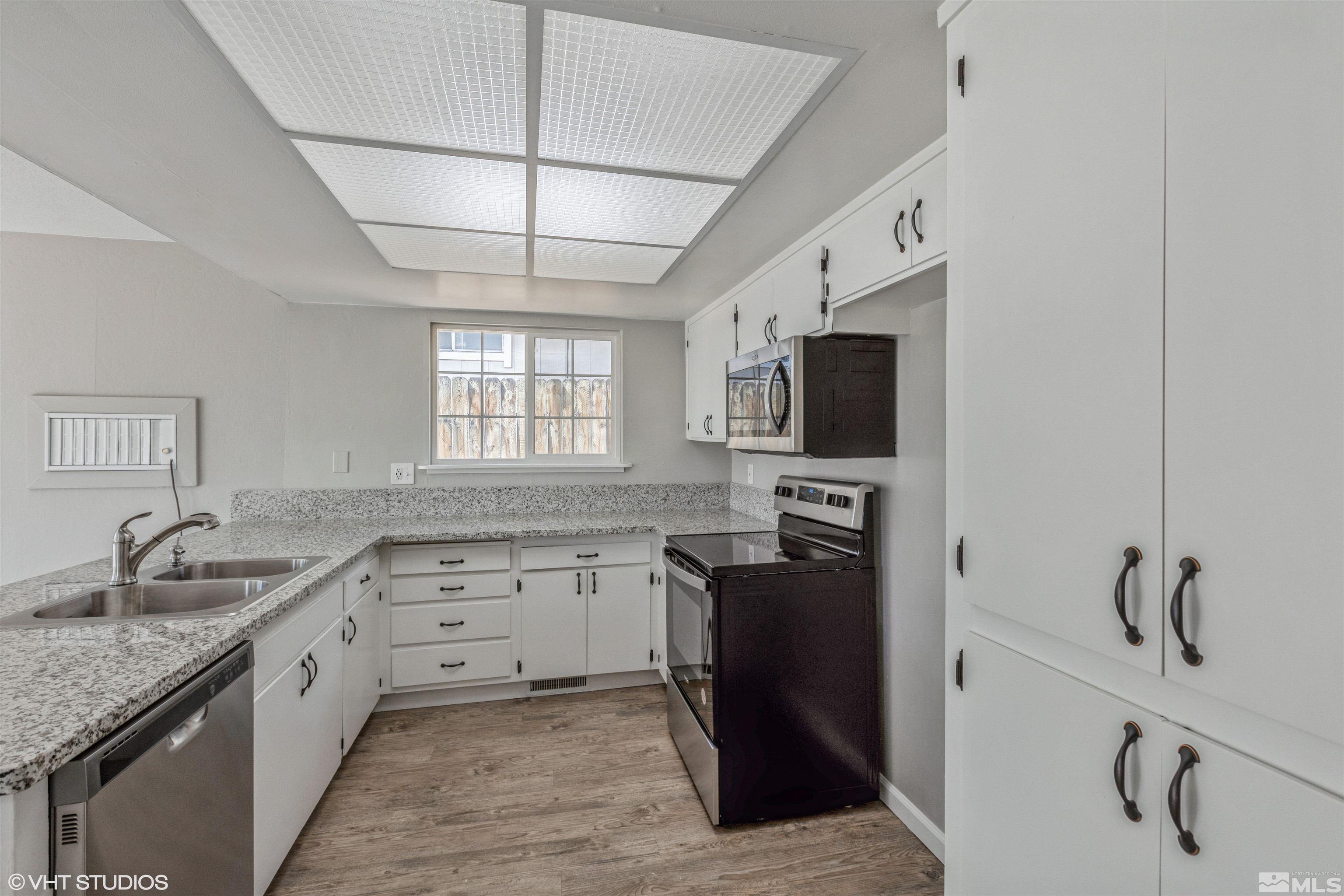 1930 Stardust Street Reno, NV 89503 - Photo 7 of 15 a kitchen with granite countertop a sink stove and refrigerator