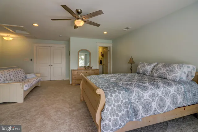 a spacious bedroom with a bed and a chandelier