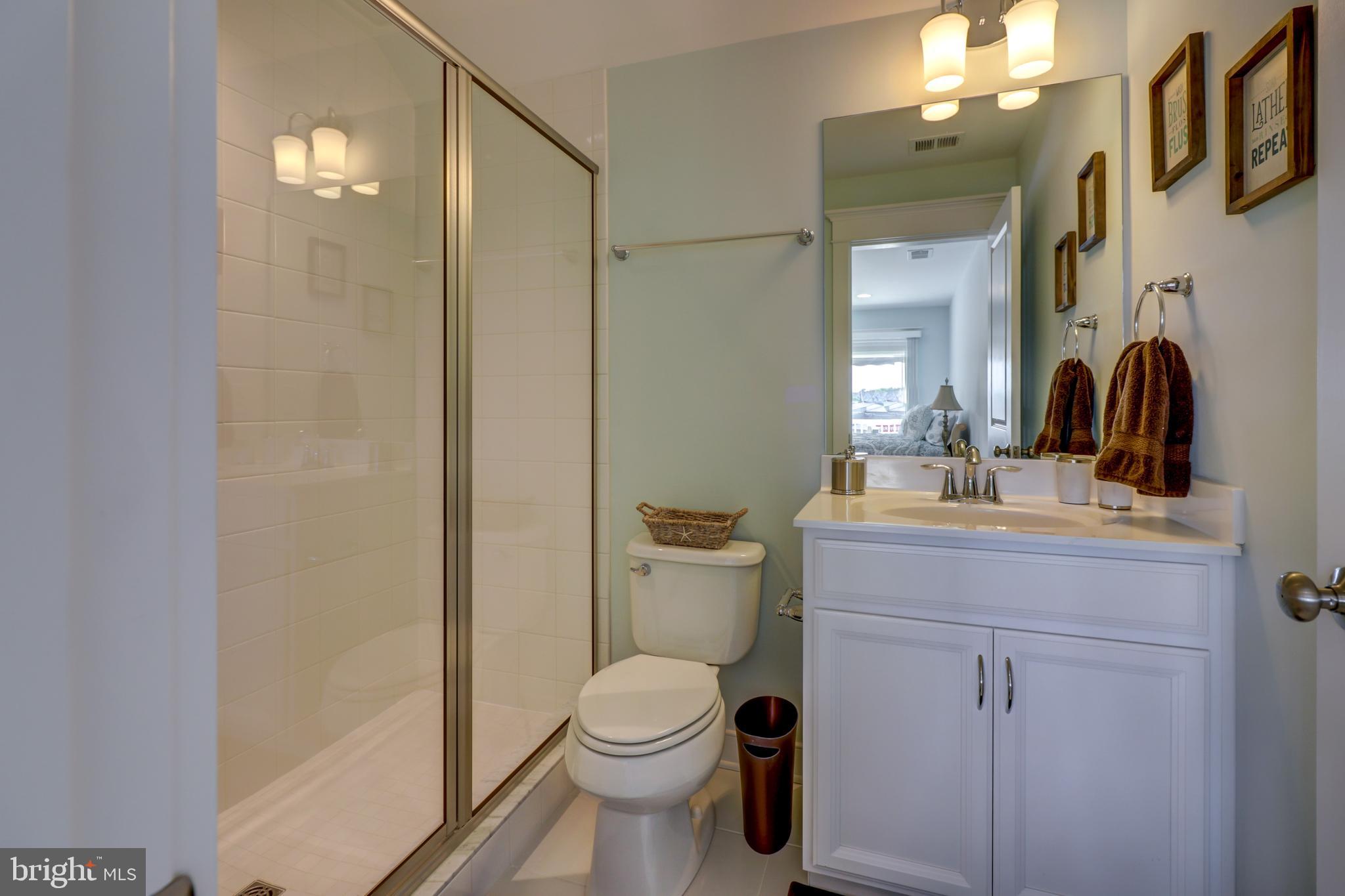 29805 Striper Harbor, Unit C3 Rehoboth Beach, DE 19971 - Photo 28 of 35 a bathroom with a toilet a sink and a mirror