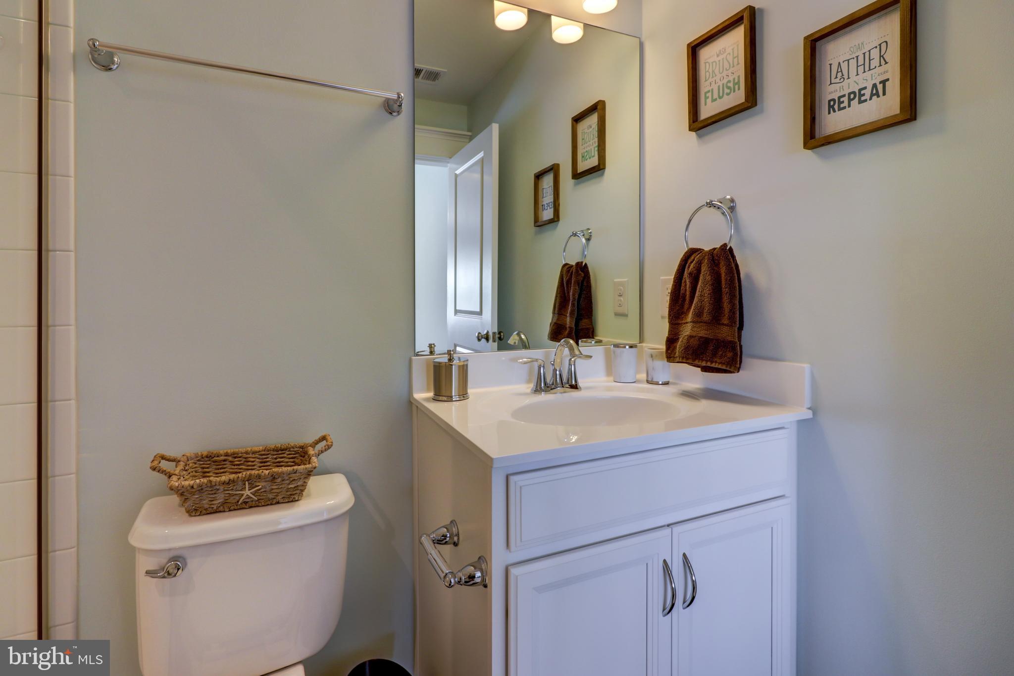 29805 Striper Harbor, Unit C3 Rehoboth Beach, DE 19971 - Photo 29 of 35 a bathroom with a sink and a mirror