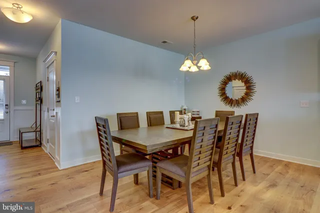 a dining room with furniture wooden floor a chandelier