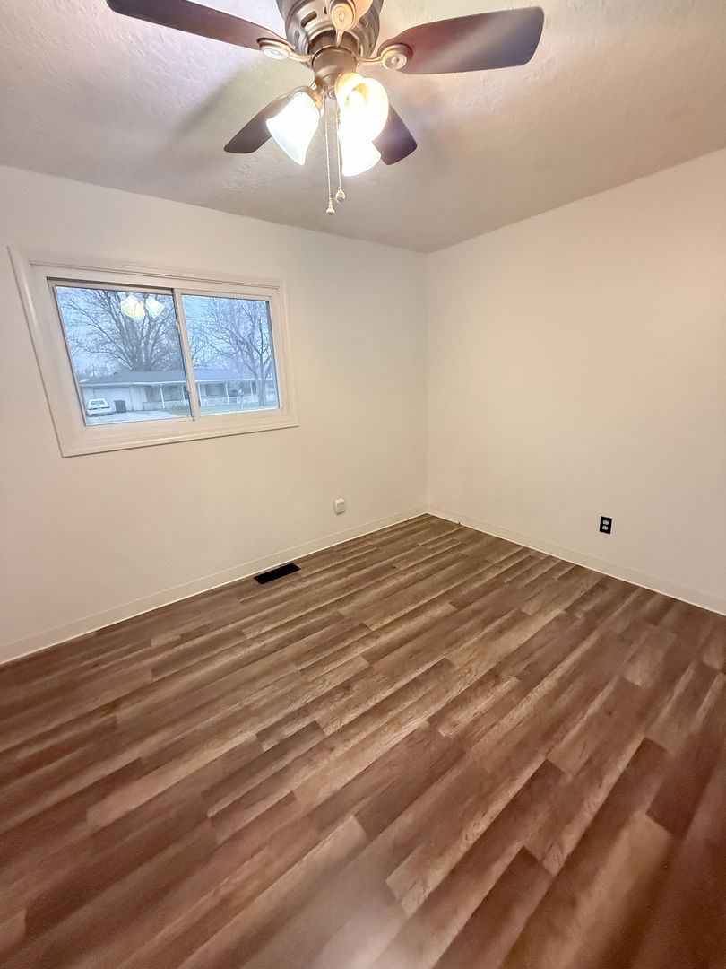 412 Hillcrest Avenue Rochelle, IL 61068 - Photo 12 of 13 an empty room with wooden floor fan and windows