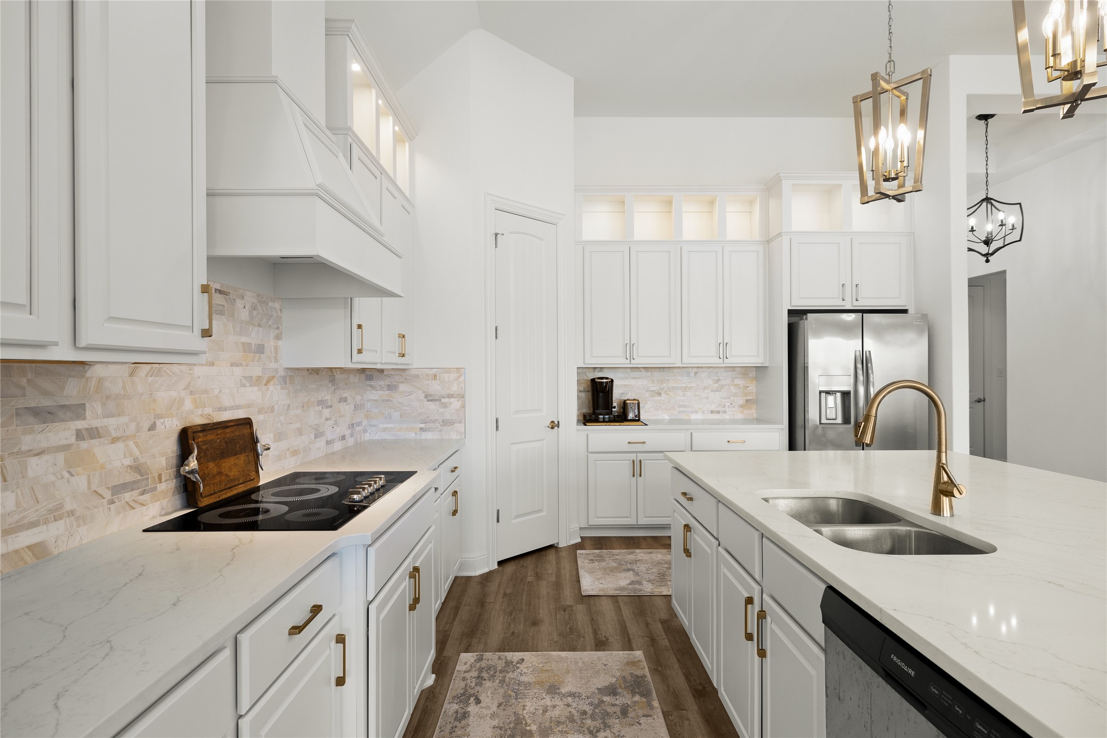 101 Bosco Road Hutto, TX 78634 - Photo 13 of 34 a kitchen with a sink dishwasher a stove and white cabinets with wooden floor