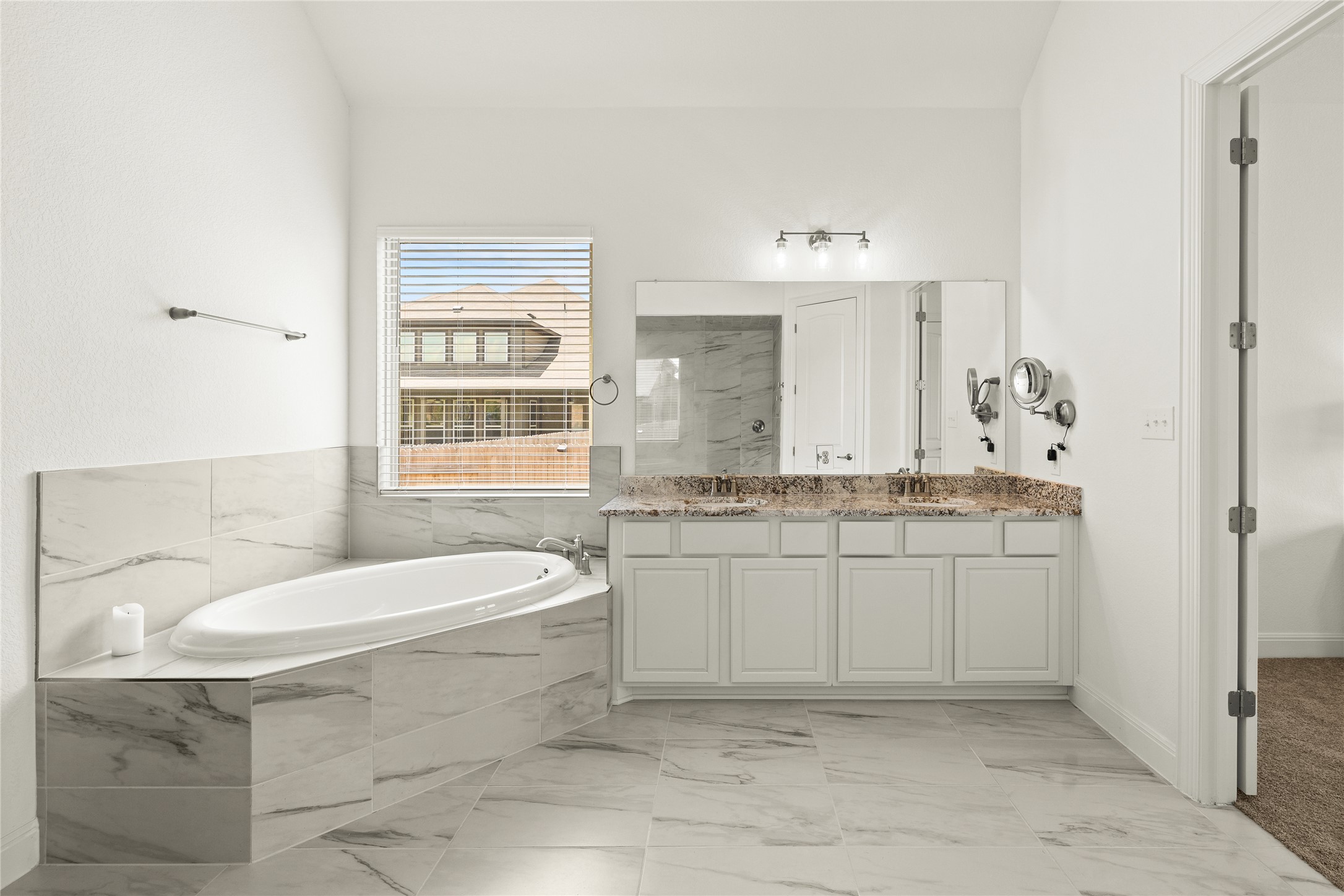 101 Bosco Road Hutto, TX 78634 - Photo 20 of 34 a bathroom with a granite countertop sink toilet a mirror and bathtub