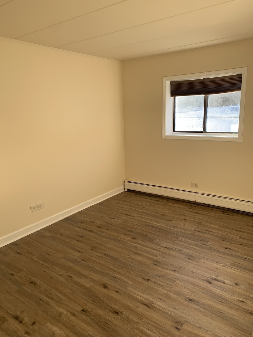 264 East Bailey Road, Unit C Naperville, IL 60565 - Photo 12 of 30 a view of an empty room with wooden floor and a window