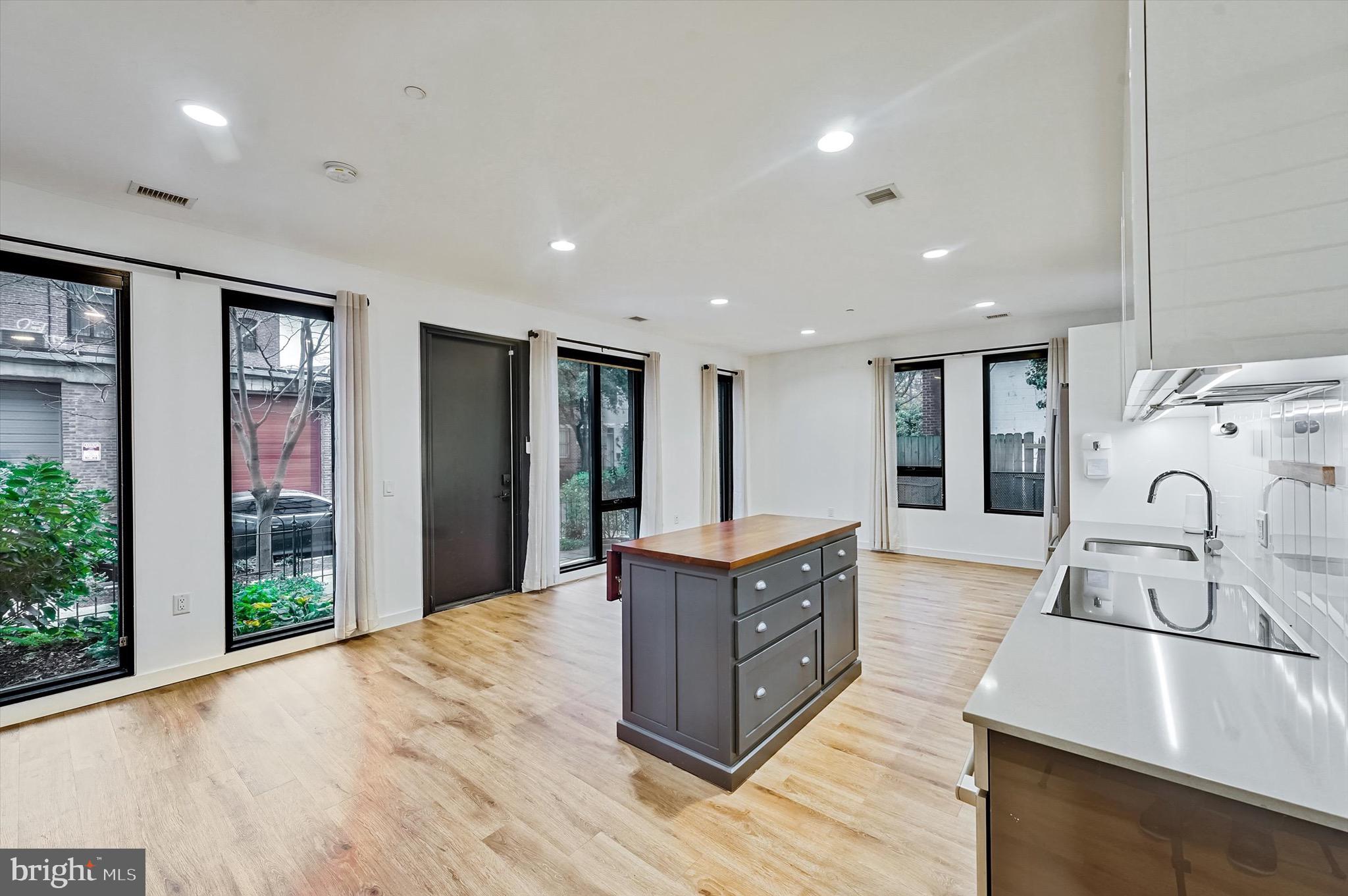 57 N Street Northwest, Unit 125 Washington, DC 20001 - Photo 13 of 56 a large kitchen with stainless steel appliances granite countertop a lot of counter space and wooden floor