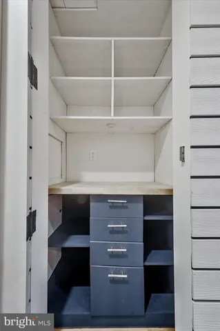 a room with lots of tables a large window and chairs