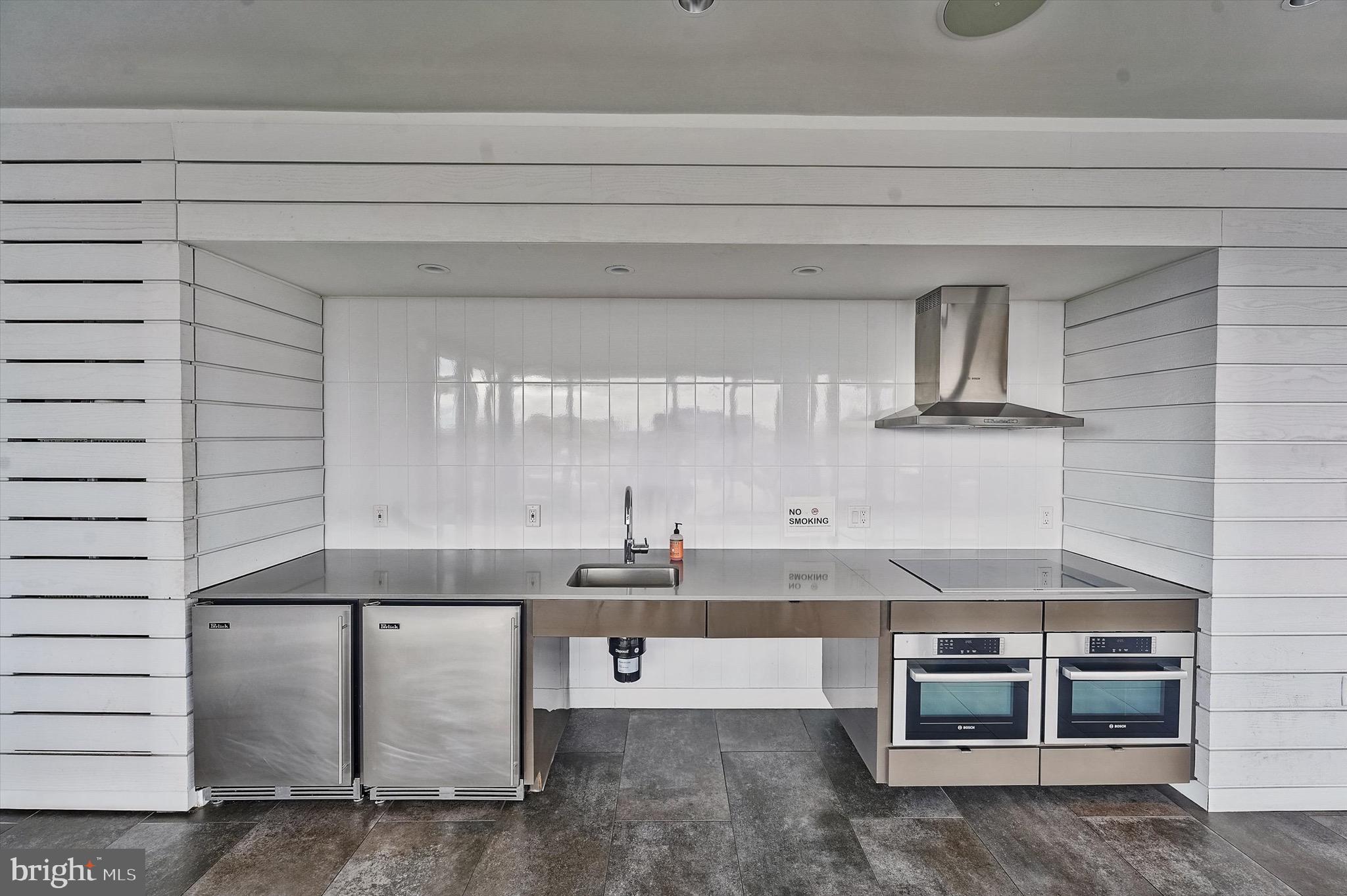 57 N Street Northwest, Unit 125 Washington, DC 20001 - Photo 43 of 56 a kitchen with kitchen island a counter top space a sink and appliances