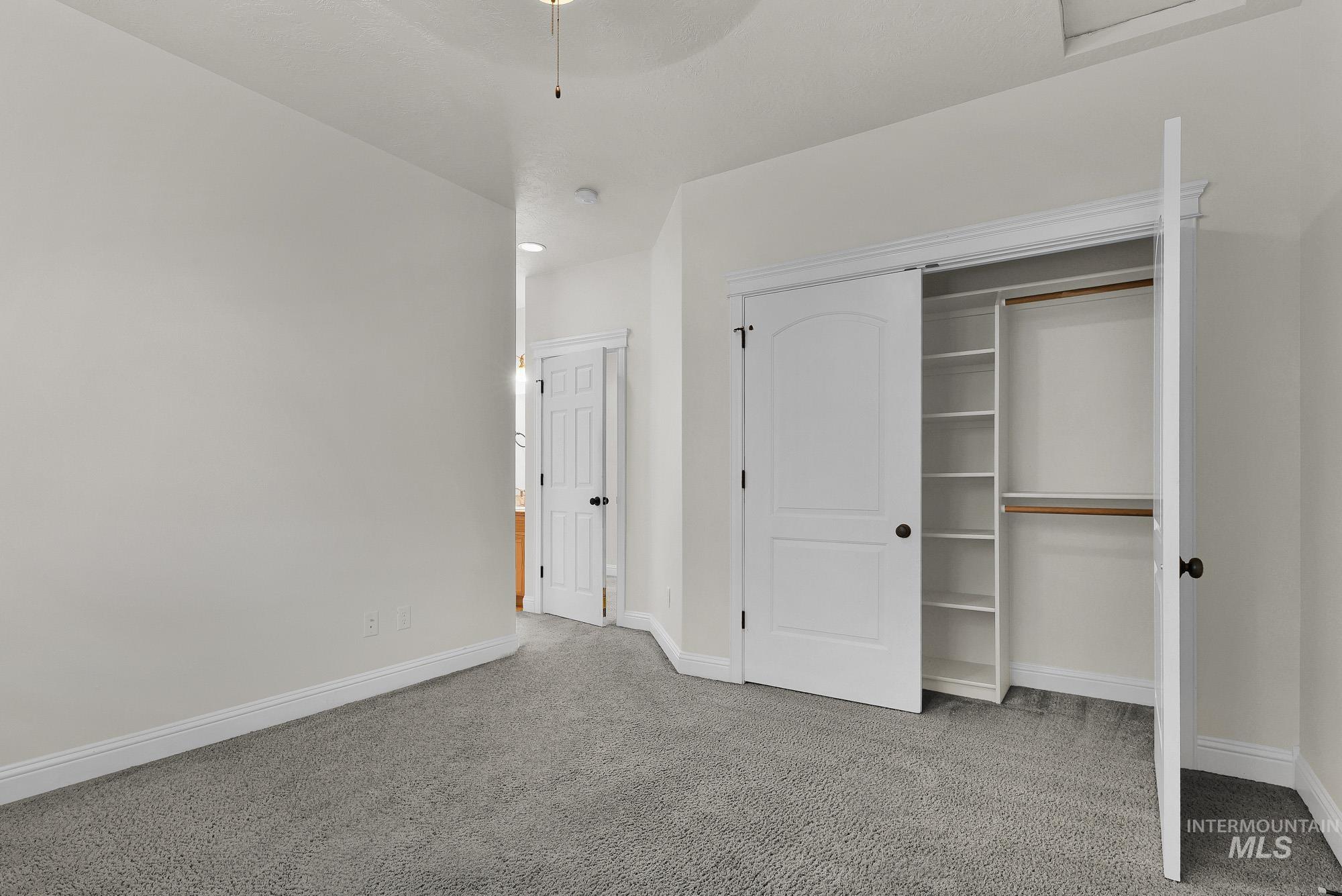 2172 West Cedar Grove Street Meridian, ID 83646 - Photo 32 of 49 Room featuring light gray carpeting, white baseboards, and a built-in closet with white bifold doors