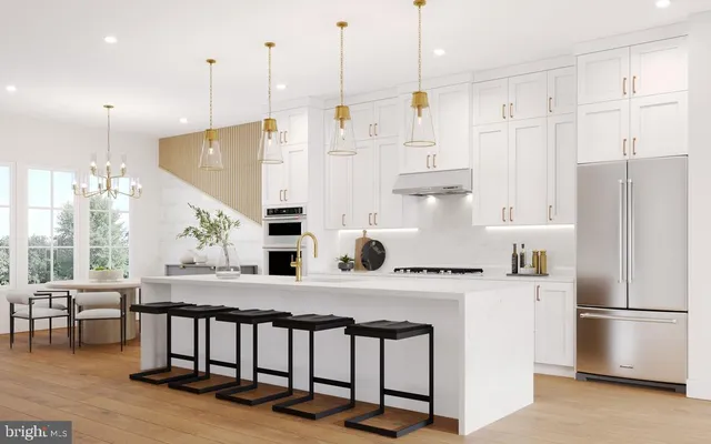 a kitchen with stainless steel appliances granite countertop a refrigerator a stove and white cabinets