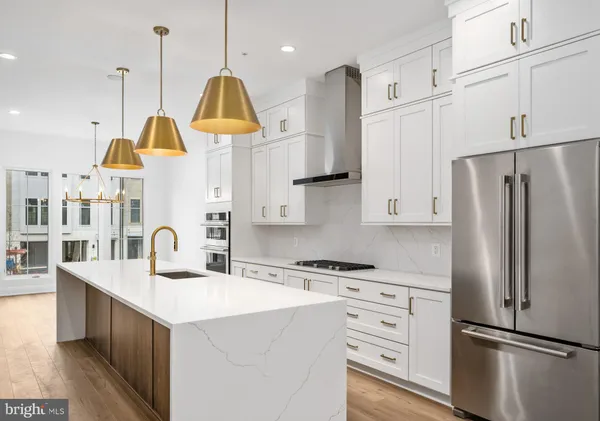 a kitchen with kitchen island white cabinets and stainless steel appliances