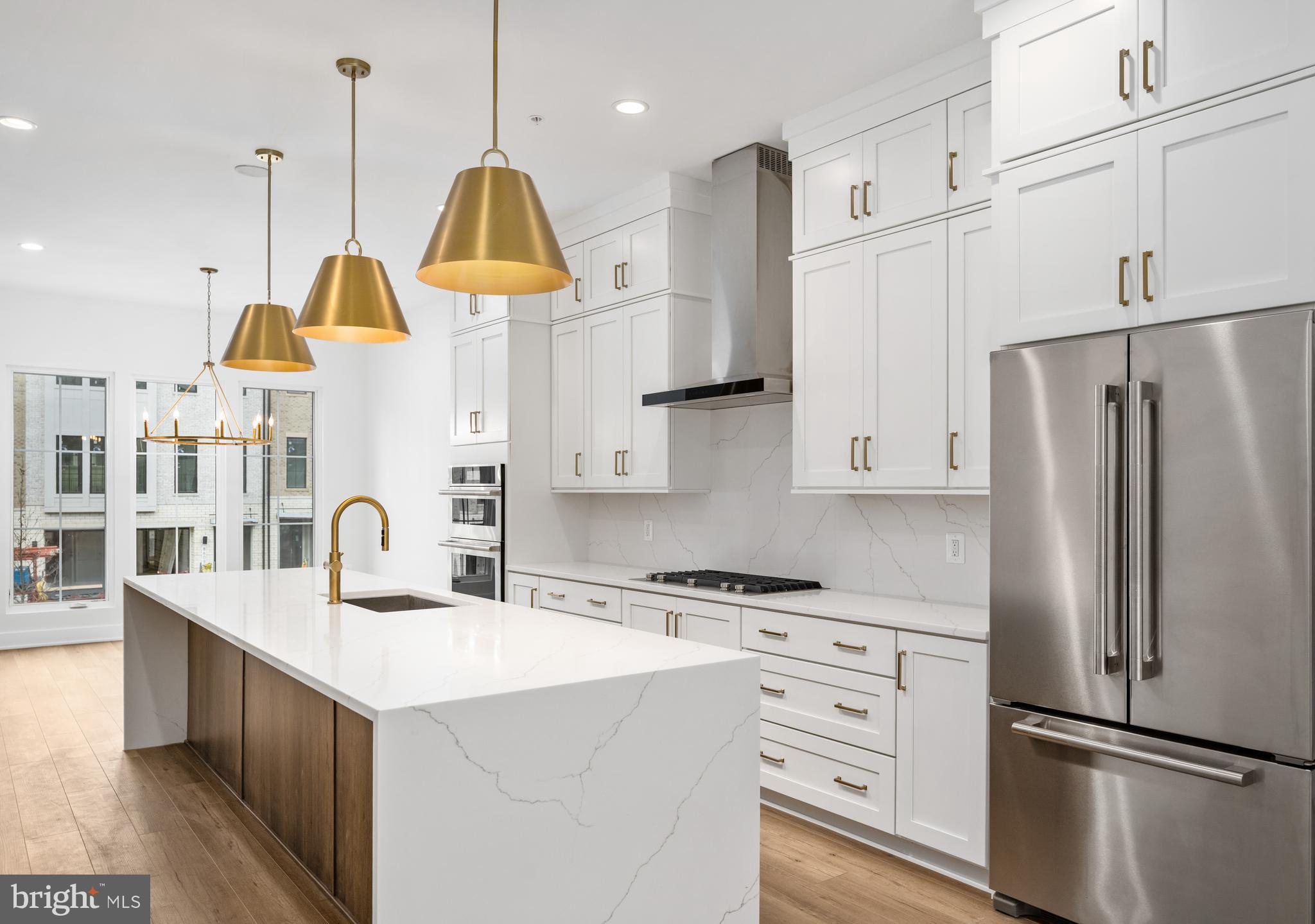 8610 Erdem Place Chevy Chase, MD 20815 - Photo 1 of 21 a kitchen with kitchen island white cabinets and stainless steel appliances