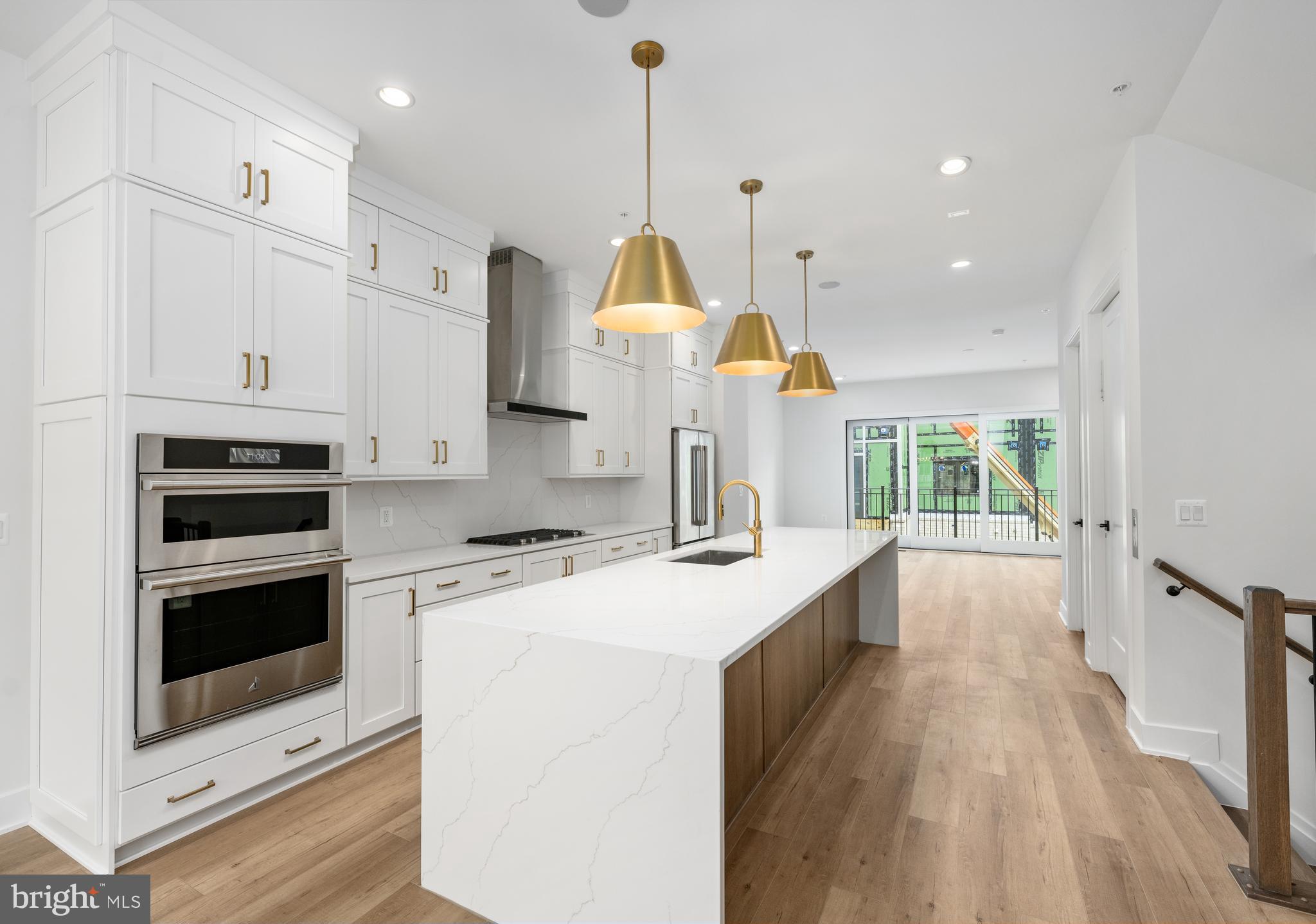 8610 Erdem Place Chevy Chase, MD 20815 - Photo 3 of 21 a kitchen with kitchen island a stove a sink a center island and a wooden floor