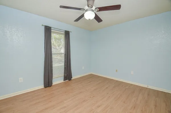 an empty room with closet and a ceiling fan