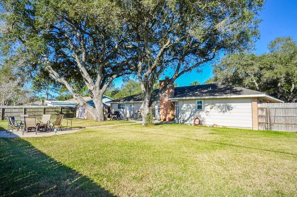 a view of a house with a big yard and large trees