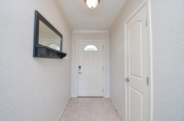 a view of a hallway with wooden floor and entryway