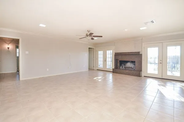 an empty room with windows and a fireplace
