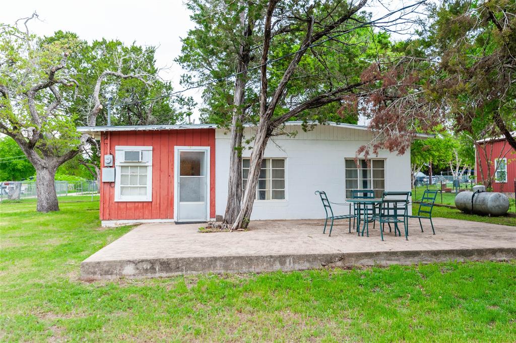 a view of a house with a yard and a table and chairs