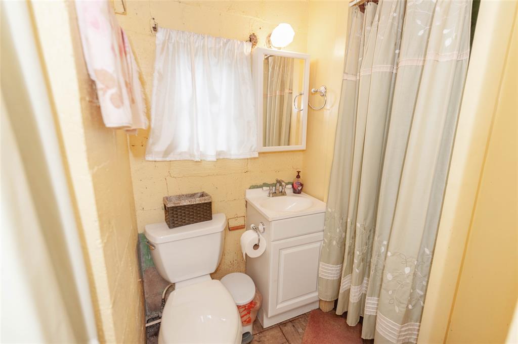 137 Center Loop Whitney, TX 76692 - Photo 21 of 33 a bathroom with a toilet and a shower curtain