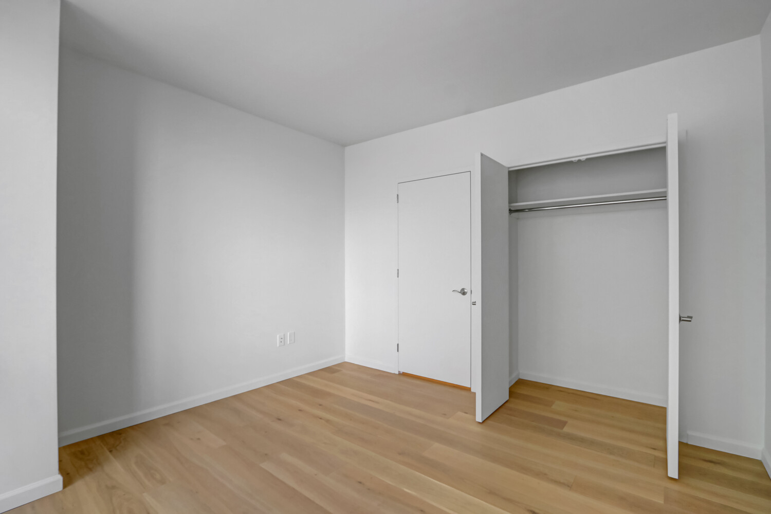 635 West 42nd Street, Unit 7A Manhattan, NY 10036 - Photo 27 of 28 a view of an empty room with wooden floor & closet