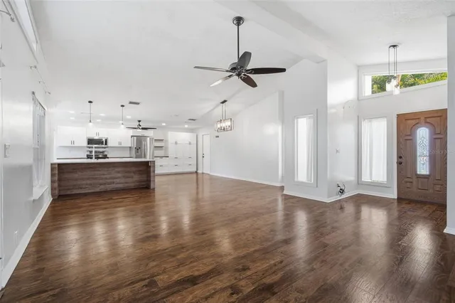 a view of a room with wooden floor and a ceiling fan