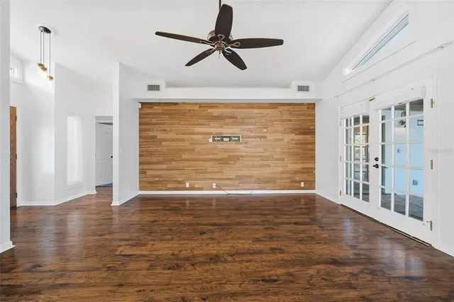 a large white kitchen with stainless steel appliances a large window a oven and a refrigerator