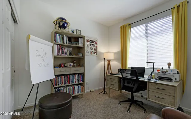 a view of a workspace with furniture and a window