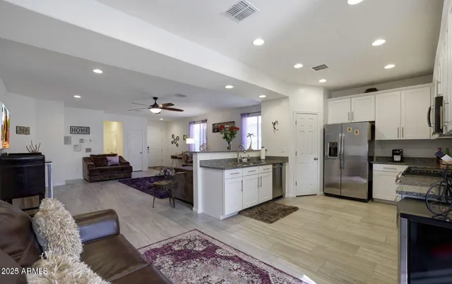 a living room with furniture a flat screen tv and a window