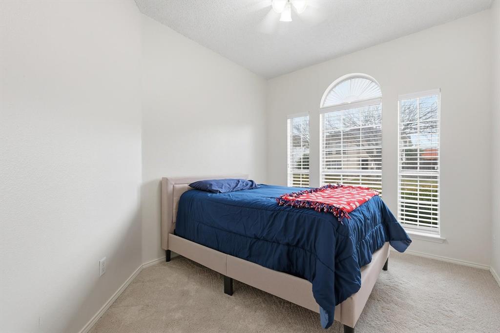 705 Squire Court Allen, TX 75002 - Photo 20 of 27 a bed sitting in a bedroom next to a window
