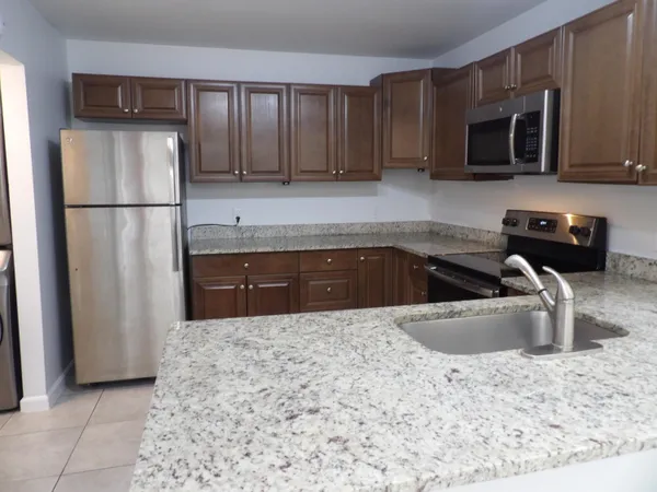 a kitchen with sink a microwave and refrigerator