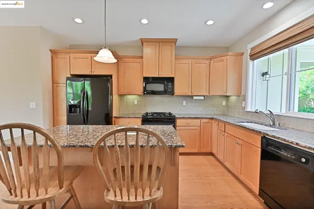 a kitchen with granite countertop white cabinets and window