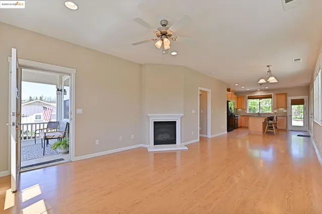 a view of an empty room with a fireplace and a window