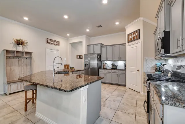 a kitchen with stainless steel appliances granite countertop a sink a stove a refrigerator and a cabinets