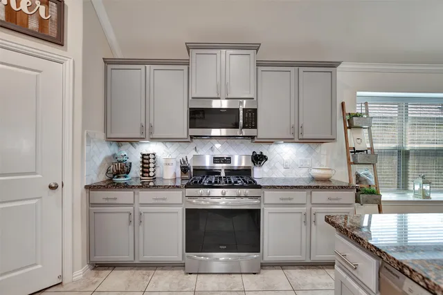 a kitchen with stainless steel appliances granite countertop a stove sink microwave and cabinets