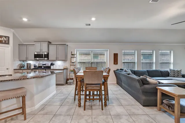 a living room with granite countertop furniture a fireplace and a view of kitchen
