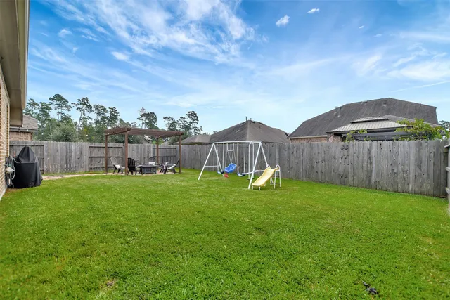 a view of a backyard with table and chairs under an umbrella